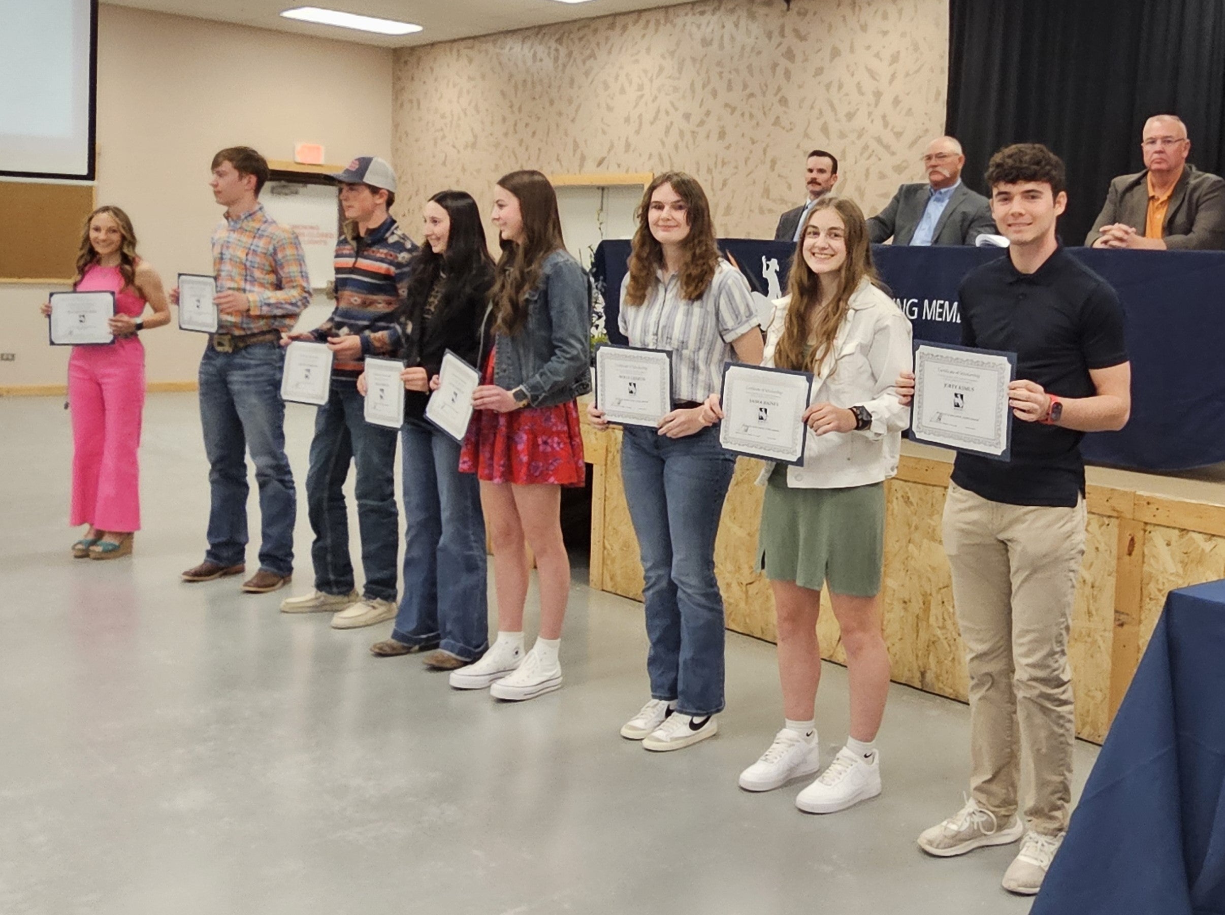 Students holding scholarship certificates